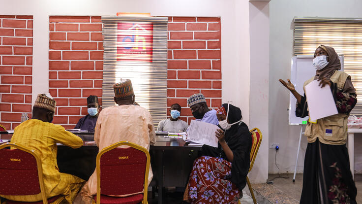 Group discussion, with woman standing on the right leading discussion